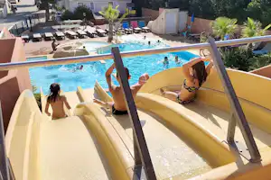 Pool im Campingbereich mit mehreren Liegen und Sonnenschirmen, Blick von einer Terrasse mit Geländer.