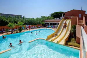Großer Camping-Pool mit Wasserrutsche, Liegen am Beckenrand und mehreren Personen im Wasser.