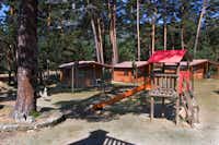 Camping Cobijo - Spielplatz und Mobilheime zwischen Bäumen