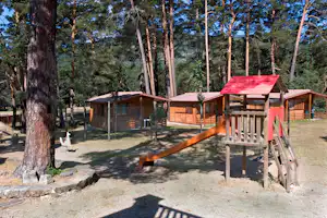 Camping Cobijo - Spielplatz und Mobilheime zwischen Bäumen
