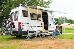 Camping Colline de Rabais - Camper sitz vor dem Wohnmobil im Schatten der Markise--