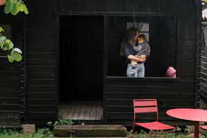 wecamp Cudillero - Mutter mit Kind auf der Terrasse einer Mietunterkunft
