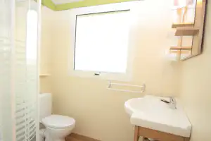 Modernes Badezimmer mit Waschbecken, WC, Fenster und Handtuchhalter an der Wand.