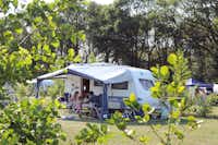 Camping Dal van de Mosbeek - Camper sitzen vor dem Wohnmobil im Schatten der Markise