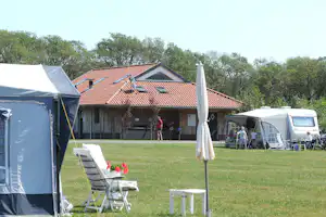 Camping Dal van de Mosbeek - Wohnwagenstellplätze mit dahinterliegenden Sanitäranlagen