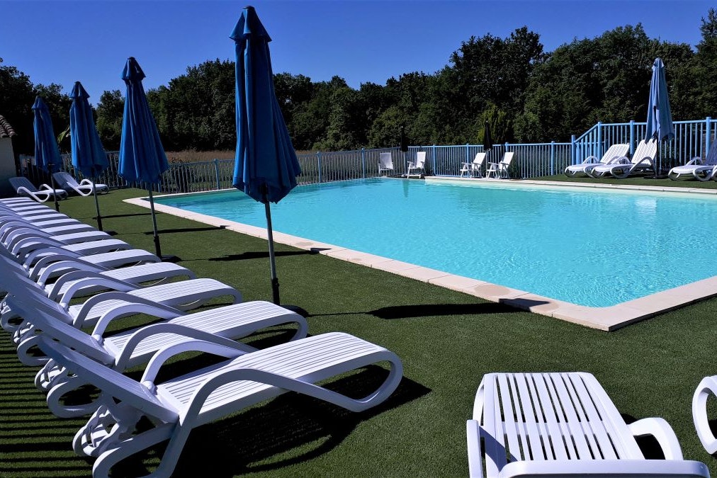 Camping De Bergougne - Blick auf Poolbereich mit Liegestühlen und Sonnenschirmen auf dem Campingplatz