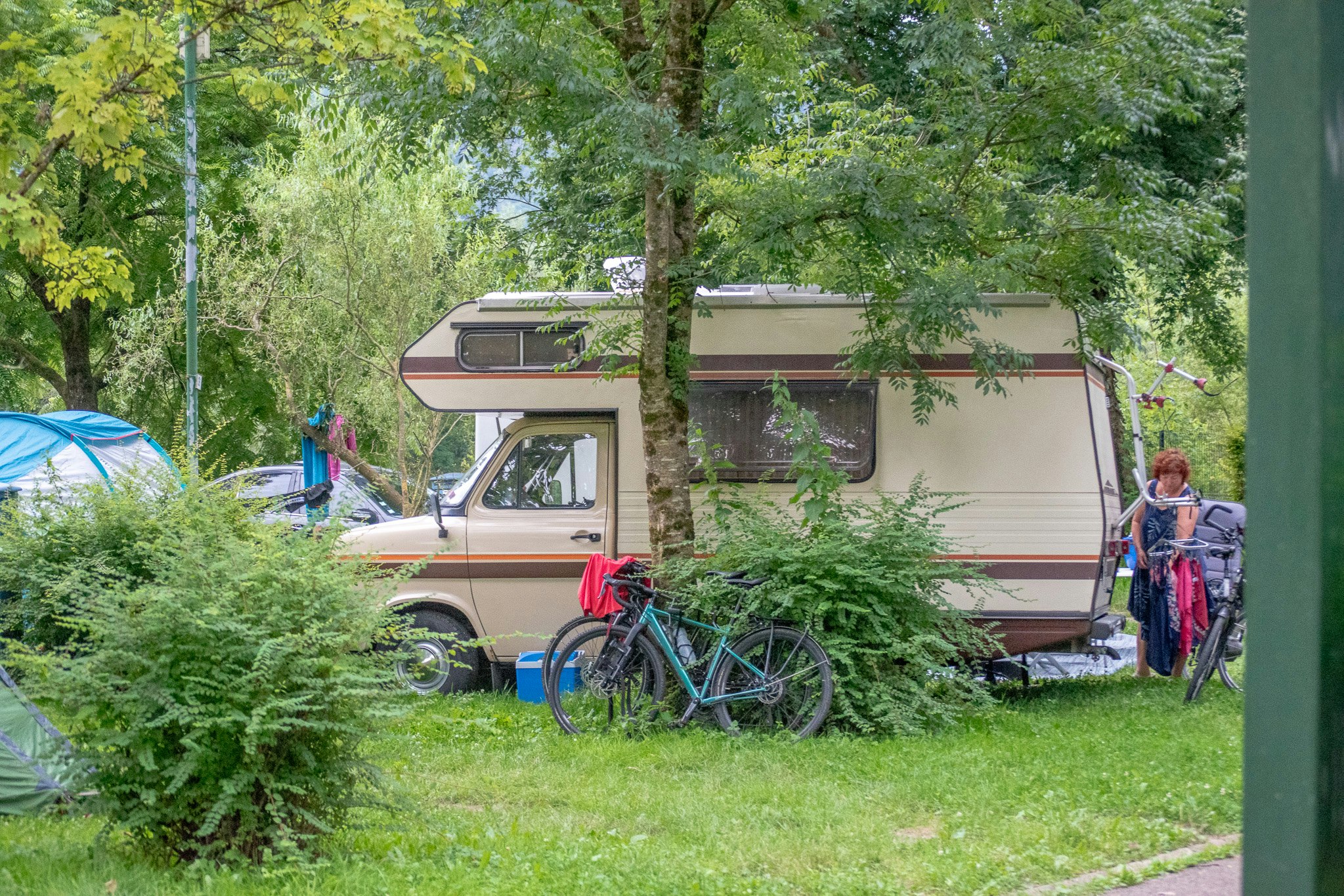 Onlycamp Camping de Besançon  - Wohnmobil- und Wohnwagenstellplätze auf der Wiese unter Bäumen
