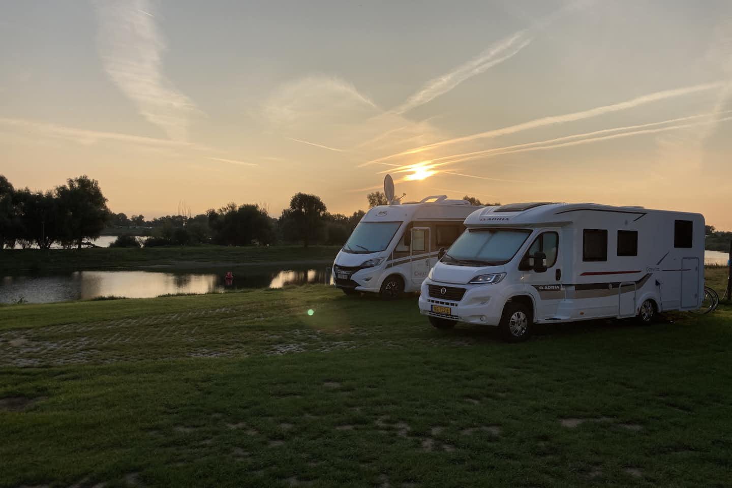 Camping De Boomgaard - Stellplätze am Wasser bei Sonnenuntergang