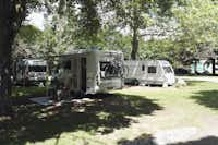 Camping de Bouthezard - vor dem Wohnmobil sitzen Camper im Schatten