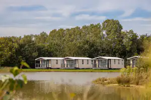 Camping De Eikenhof - Mobilheime auf dem Campingplatz mit Blick auf den See