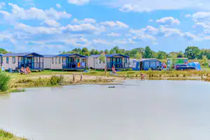 Camping De Eikenhof - Blick auf den See und die Mobilheime auf dem Campingplatz
