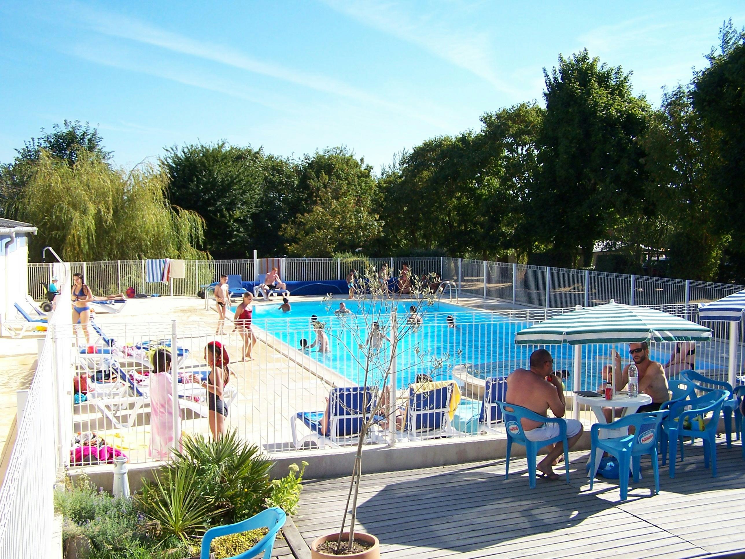 Camping De Kernéjeune  - Pool im Freien mit Liegestühlen und Sonnenschirmen