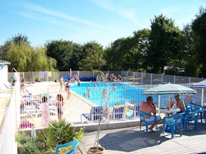 Camping De Kernéjeune - Pool im Freien mit Liegestühlen und Sonnenschirmen