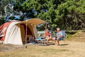 Camping De Kiekduun - Paar sitzt auf Campingstühlen vor ihrem Zeltplatz