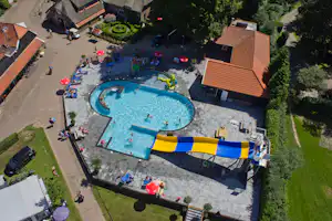 Camping De Koeksebelt - Luftaufnahme des Freibads mit Wasserrutsche, Liegestühlen und Sonnenschirmen