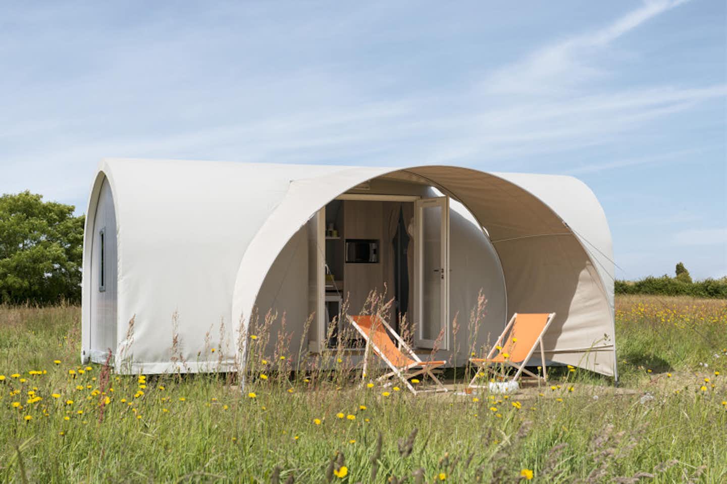 Camping de l' Arquebuse - Mobilheim vom Campingplatz mit Veranda und Liegestühlen auf einer Blumenwiese