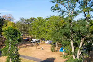 Camping de L'Île - Standplätze zwischen den Bäumen auf dem Campingplatz