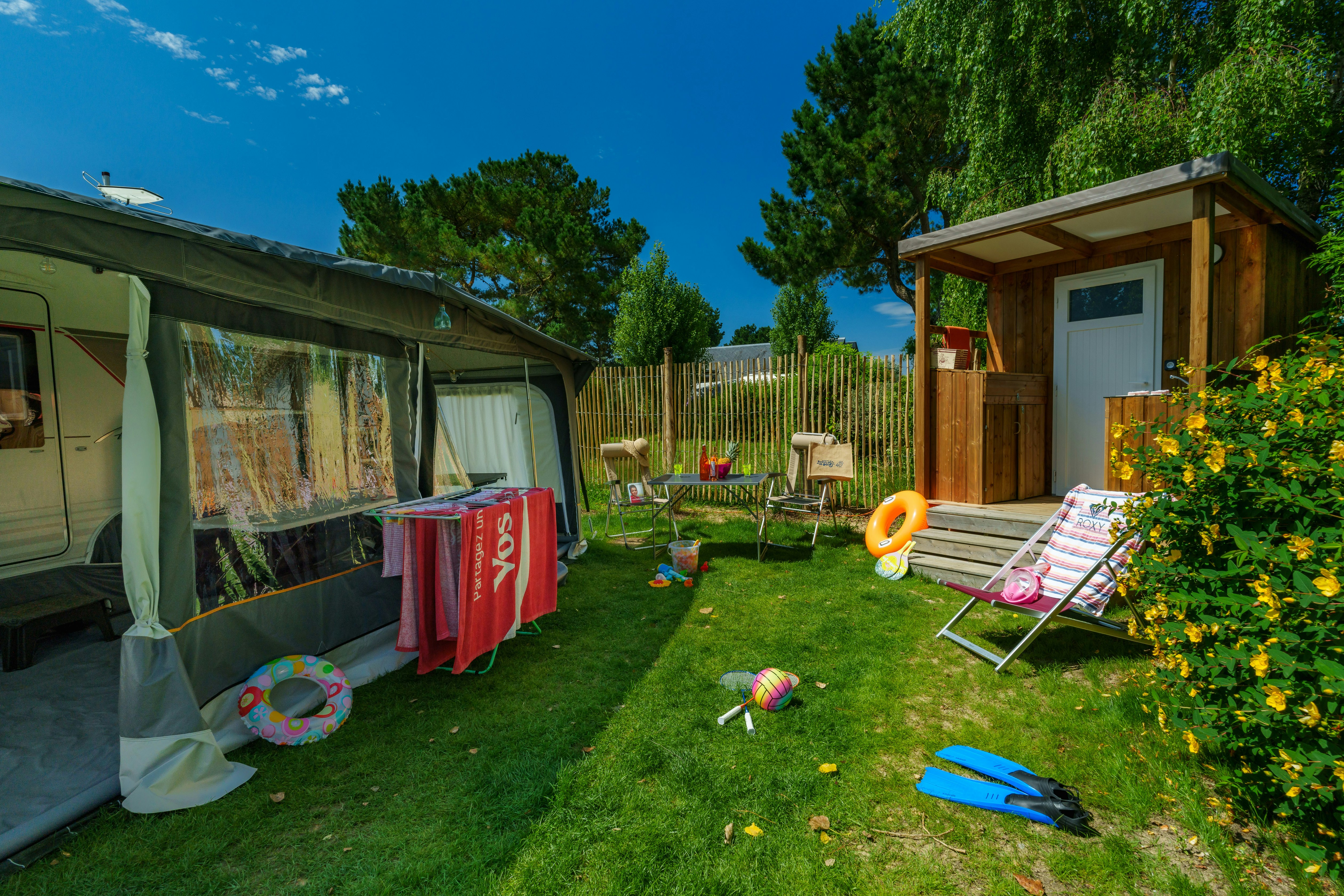 Camping de la Baie - Standplatz mit Wohnwagen und WC Häuschen