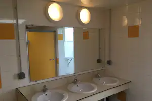 Camping de La Côte des Légendes - Innenraum des Sanitärgebäudes mit Waschbecken und Spiegeln