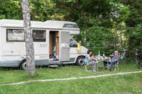 Camping de la Forêt - Camperpaar vor ihrem Wohnwagen in der Sonne