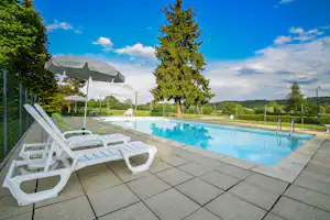 Camping de la Forêt- Pool mit Liegestühlen und Sonnenschirmen auf dem Campingplatz