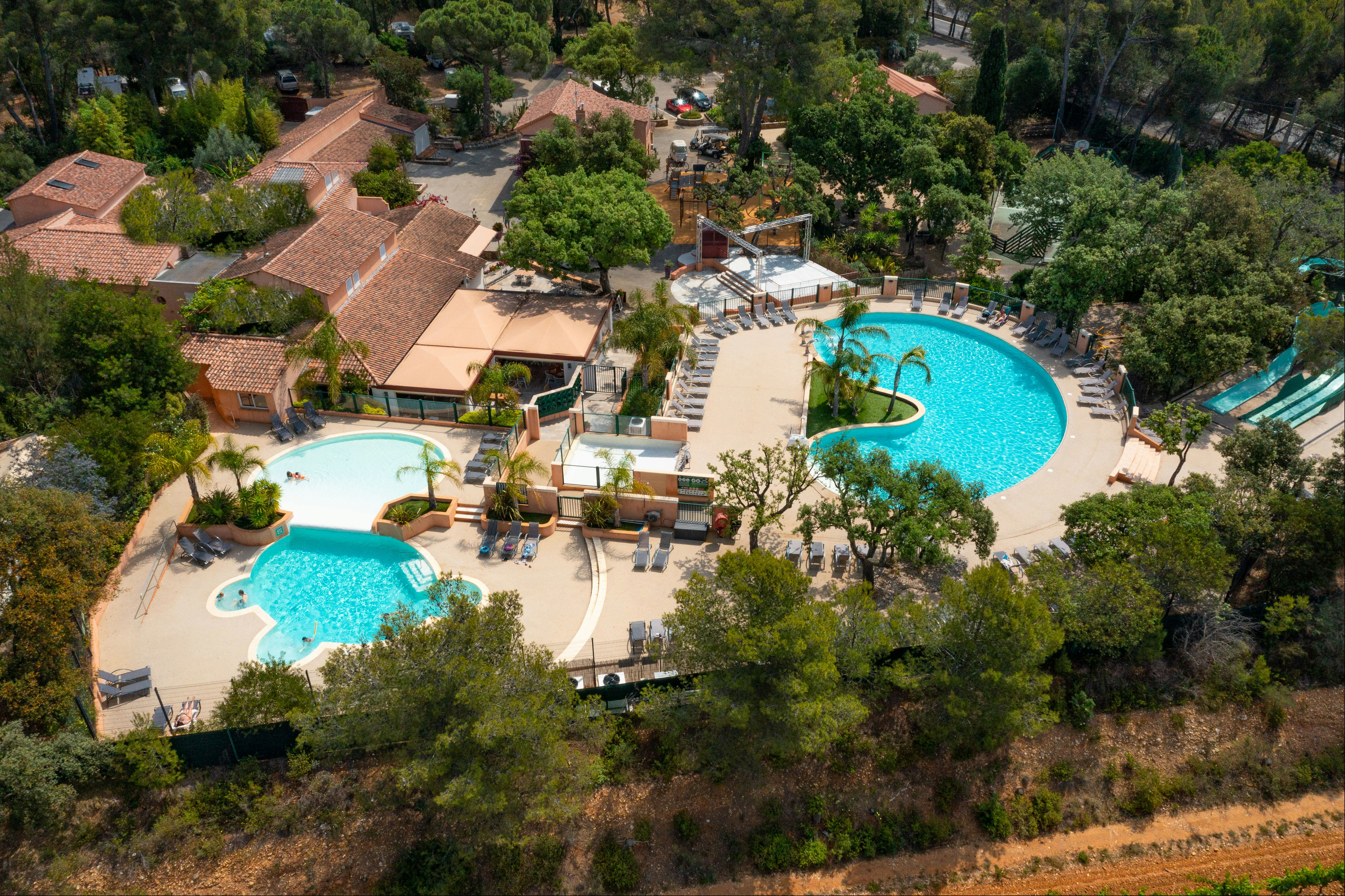 Les Jardins de La Pascalinette Vogelperspektive auf die Hauptgebäude, das Restaurant und die Pools des Campingplatzes