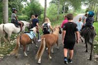 Camping de la Trye - Kinder beim ausreiten von Ponys auf einer Strasse beim Campingplatz