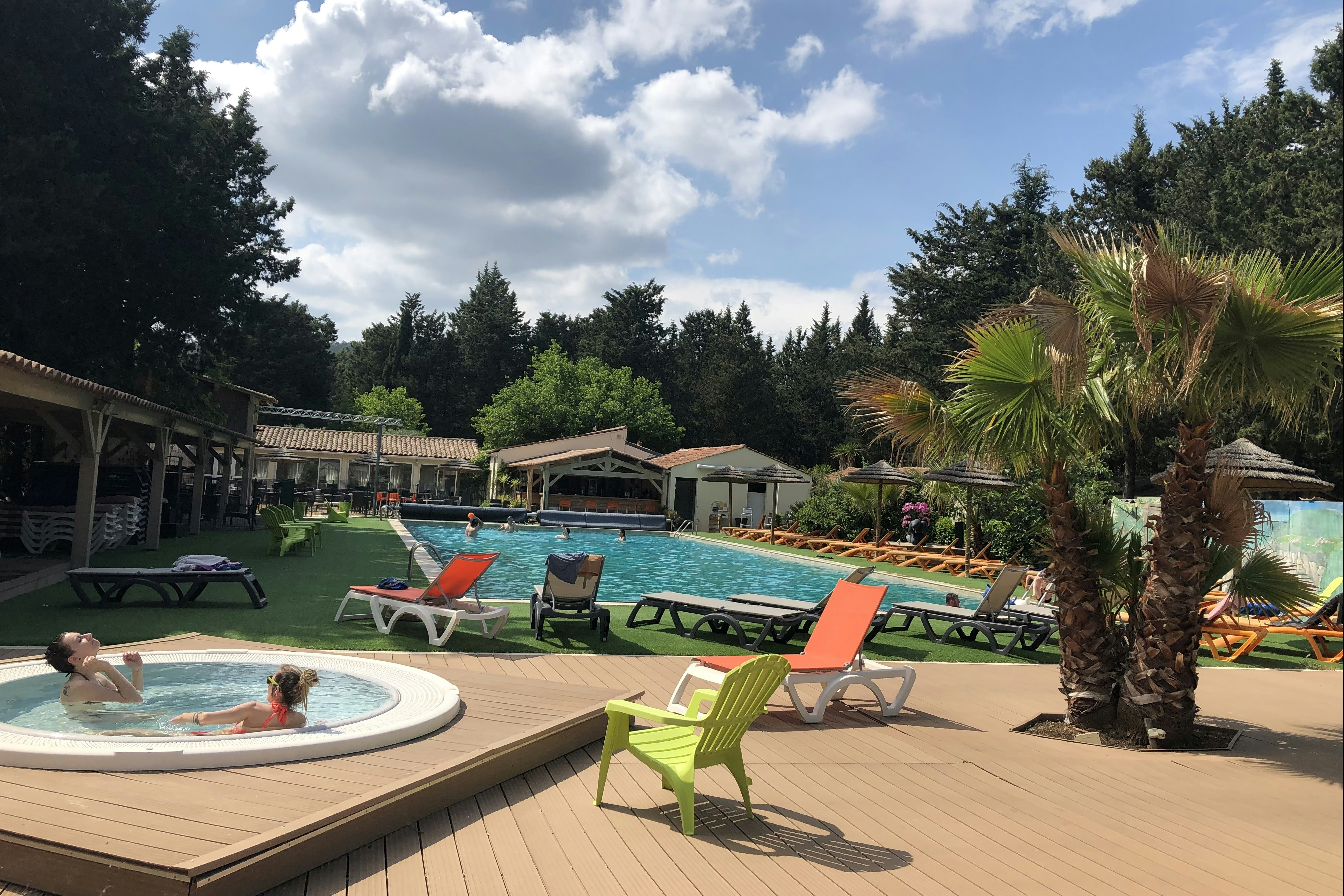 Camping de La Vallée de Taradeau - Blick auf das Freibad mit Liegestühlen und Sonnenschirmen