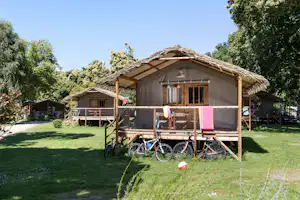Camping de la Ville Huchet - Fahrräder an den Mobilheimen vom Campingplatz mit Veranden im Grünen