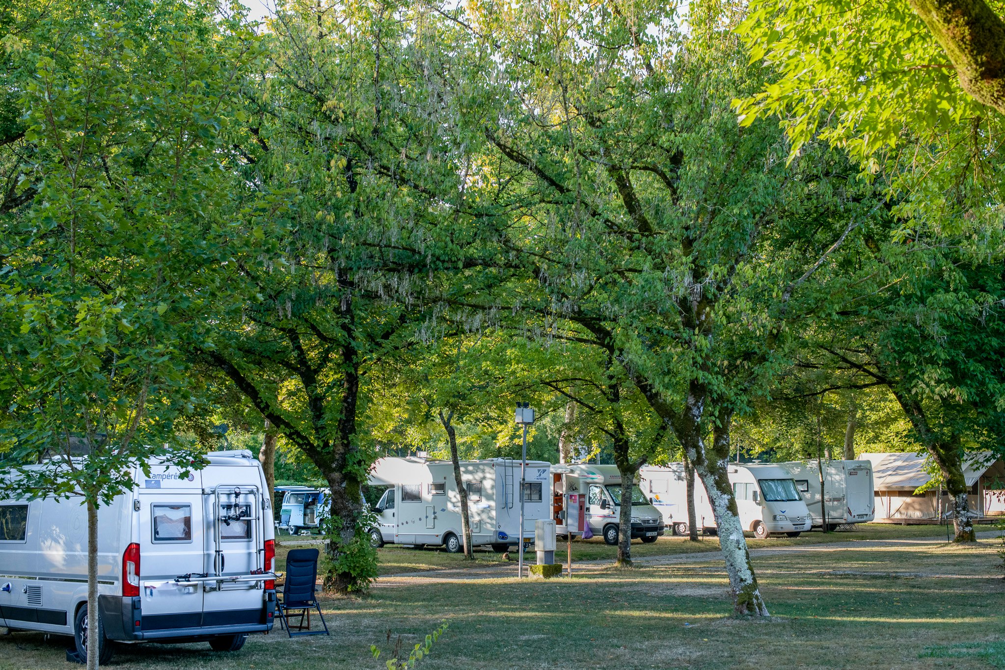 Camping de l'Argenté - Standplätze zwischen den Bäumen auf dem Campingplatz