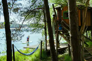 Camping De Lilse Bergen - Mietunterkünfte zwischen den Bäumen direkt am Ufer des Sees