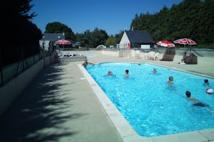 Camping de Locouarn - Poolbereich mit Liegestühlen und Sonnenschirmen