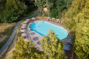 Camping de Lyon - Blick auf den Pool mit Liegestühlen und Sonnenschirmen