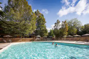 Camping de Lyon - Pool im Freien mit Liegestühlen und Sonnenschirmen