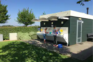 Camping De Maashoeve - Camper am Waschbecken vom Sanitärgebäude