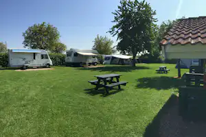 Camping De Maashoeve - Wohnwagen auf Stellplätzen vom Campingplatz und Picknicktische mit und ohne Überdachung