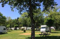 Camping de Masevaux - Wohnwagenstellplatz zwischen den Bäumen auf dem Campingplatz