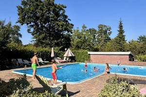 Recreatiepark de Meibeek - Pool im Freien mit Liegestühlen und Sonnenschirmen