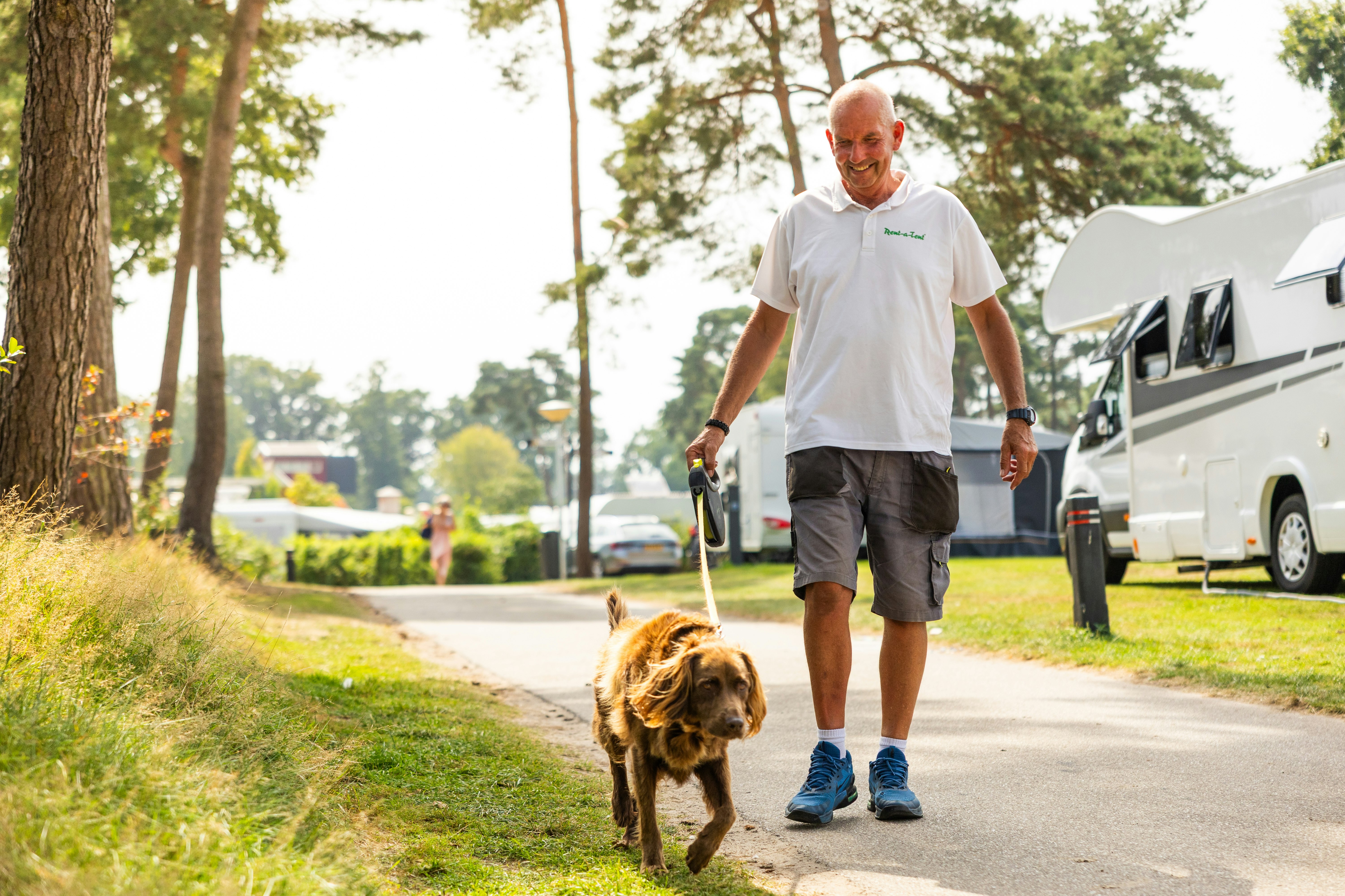 Camping De Molenhof - Camper mit Hund beim Spazieren auf dem Campingplatz