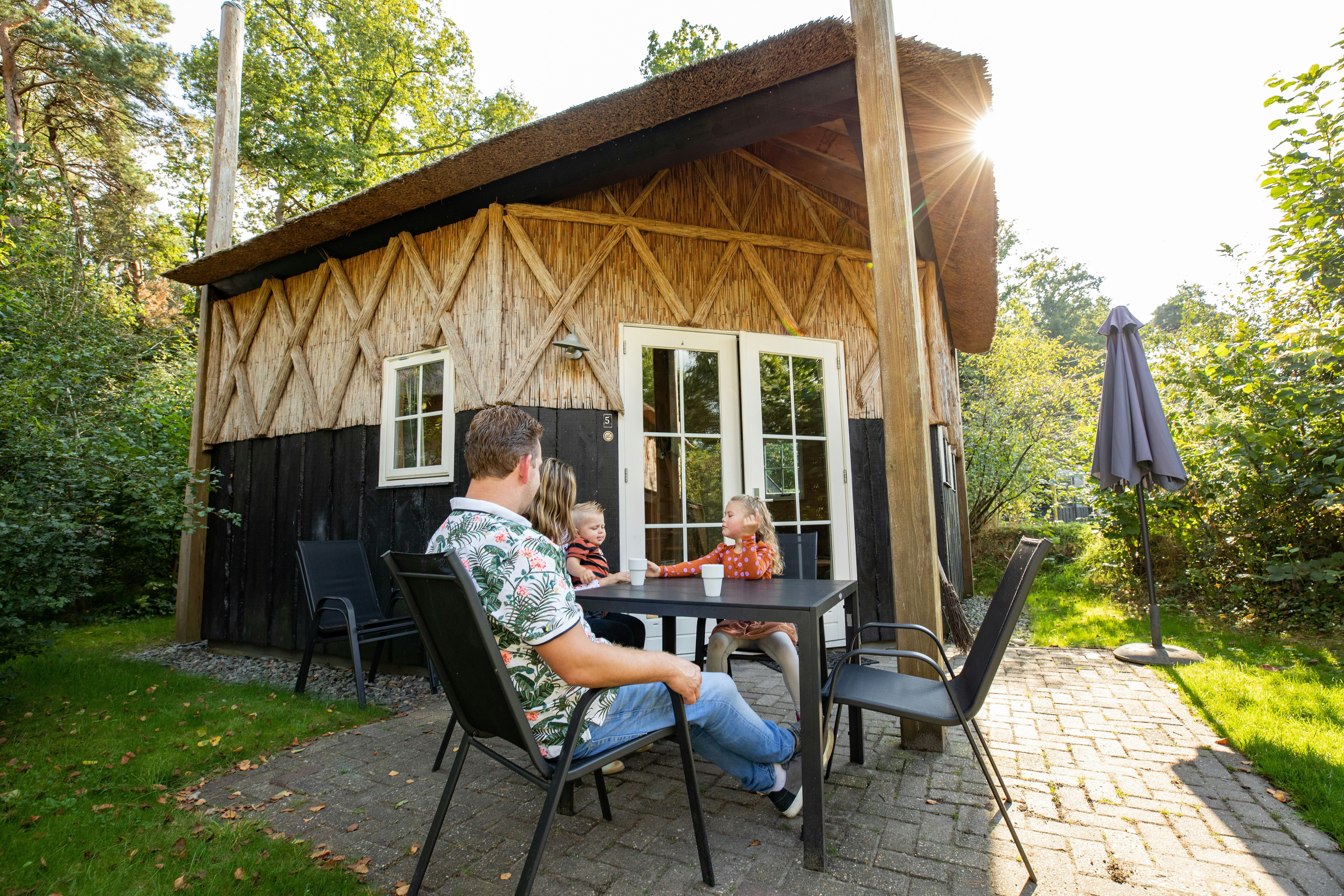 Camping de Norgerberg - Familie sitzt auf der Terrasse ihres Mobilheims