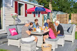 Siblu Camping de Oase Camping De Oase - Campinggäste beim gemeinsamen Frühstücken auf der Terrasse ihres Mobilheims