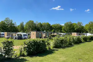 Camping De Papillon - Blick auf teilweise durch Hecken abgetrennte Standplätze mit eigenen Sanitärkabinen