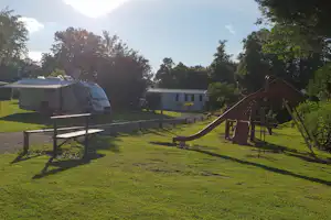 Camping De Sorel - Kinderspielplatz mit Wohnmobil und Mobilheim im Hintergrund