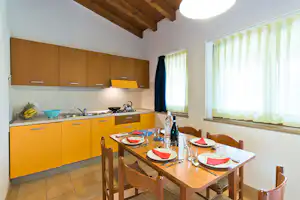Camping Del Garda- ein privates Esstimmer und Küche eines Bungalows
