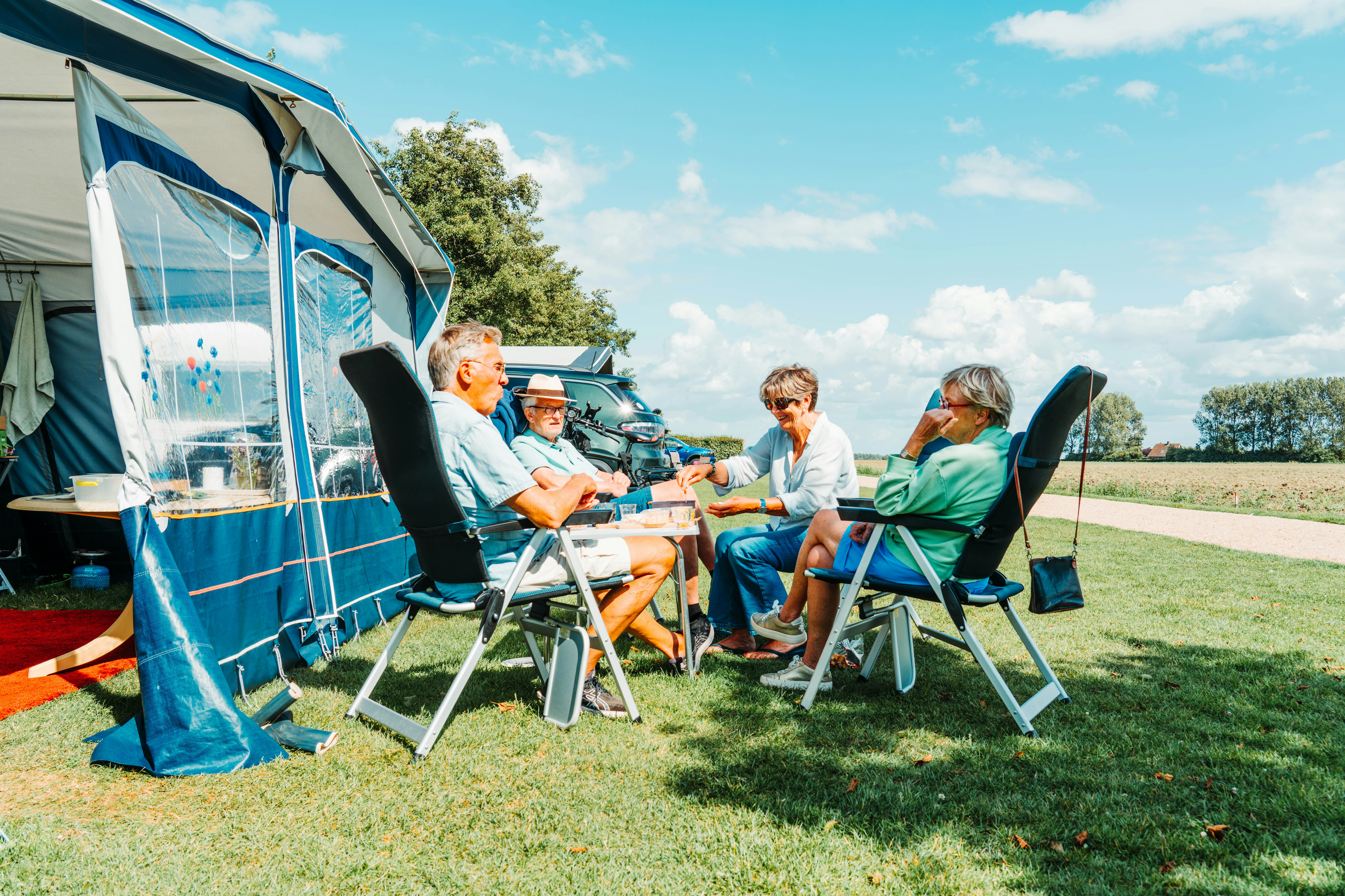 Camping Den Molinshoeve - Familie sitzt auf ihrem Standplatz