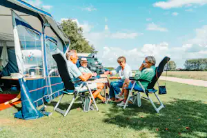Camping Den Molinshoeve - Familie sitzt auf ihrem Standplatz