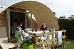 Camping des Abers - Camper mit Hund auf der Veranda vom Mobilheim auf dem Campingplatz