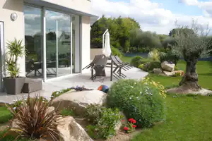 Camping des Abers - Mobilheim vom Campingplatz mit Esstisch und Sonnenschirm auf der Veranda