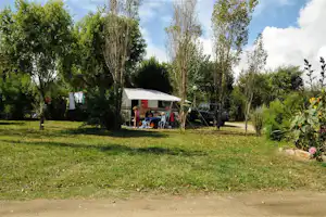 Camping des Dunes - Camper am Wohnwagen auf dem Stellplatz vom Campingplatz im Grünen