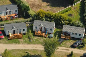 Camping des Dunes - Mobilheime vom Campingplatz mit Veranden im Grünen aus der Vogelperspektive